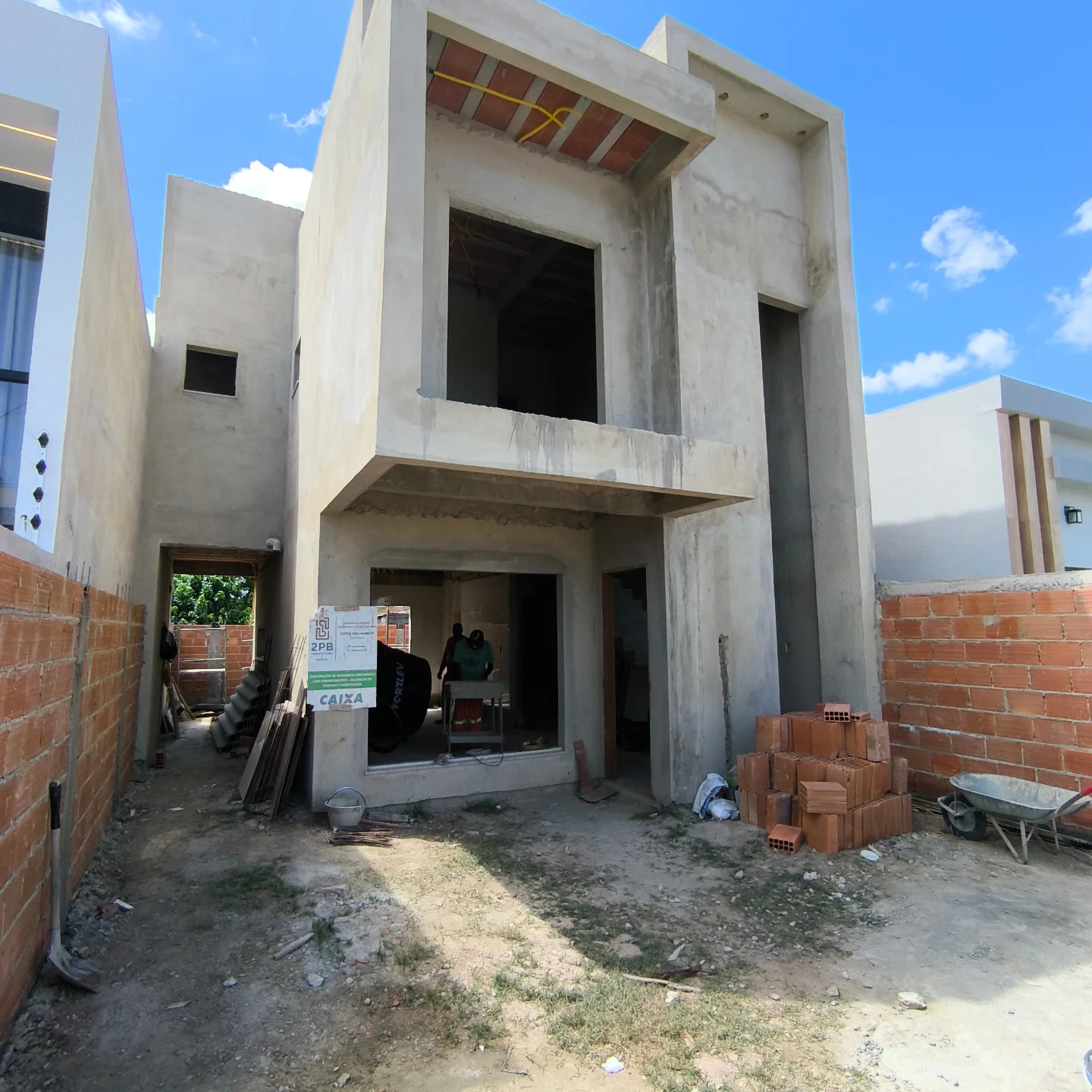 Casa em construção acompanhada pela 2PB, com materiais e estrutura aparentes.